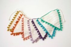 four crocheted pieces of cloth with beads on each side and two strings at the end