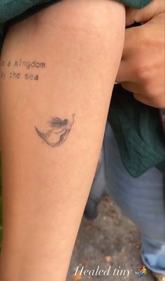 a woman with a tattoo on her leg that says, i am a kingdom by the sea