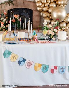 a table is set up with candles, cake and decorations for a party or celebration