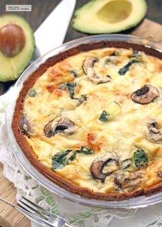 an avocado and quiche dish on a wooden cutting board