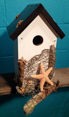 a bird house with starfish and driftwood