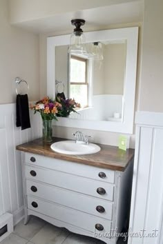 a bathroom with a sink and mirror next to a window on the wall in front of it