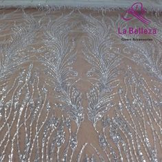 an embroidered fabric with silver beads and sequins on the bottom, in front of a