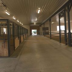 the inside of a horse barn with stalls