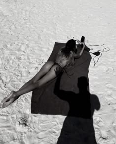 a woman laying on top of a blanket in the snow