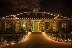 a house decorated with christmas lights and wreaths