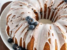 a bundt cake with icing and blueberries on a plate