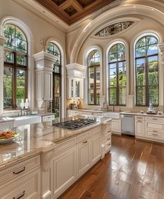 a large kitchen with white cabinets and marble counter tops, along with hardwood floorsing