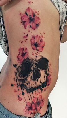 a woman's stomach with a skull and flowers on it