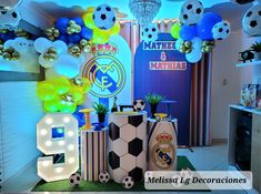 a room with balloons, soccer balls and decorations on the floor in front of it