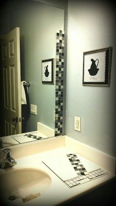 a bathroom with a sink, mirror and pictures on the wall