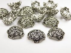 a bunch of silver colored beads on a white surface