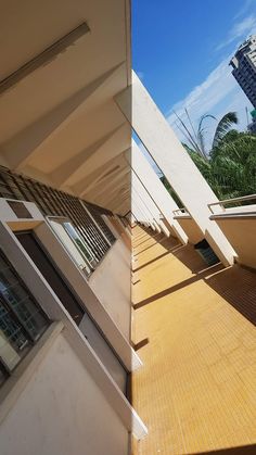 the side of a building with windows and balconies next to each other on a sunny day