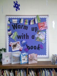 a book shelf with books on it in front of a sign that says warm up with a book