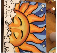 an art project with sun and clouds painted on it