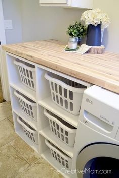 a washer and dryer sitting next to each other in a room with tile flooring