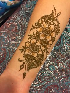 a woman's foot with henna tattoos on it