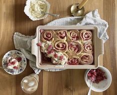 a pan filled with desserts sitting on top of a wooden table next to other dishes