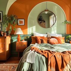 a bedroom with orange walls and green bedding in the corner, an arched mirror hangs on the wall