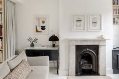 a living room filled with furniture and a fire place in front of a book shelf