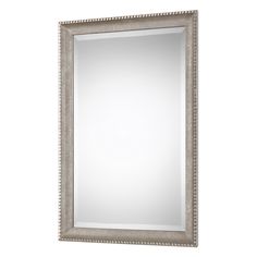 a silver framed mirror on a white wall