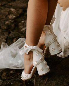 a close up of a person wearing high heels with pearls on the toes and ankles