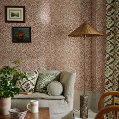 a living room filled with furniture and a lamp on top of a hard wood table