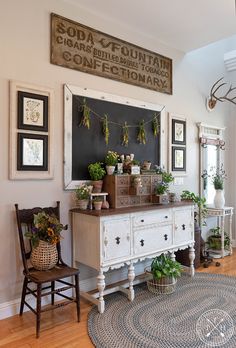 an old dresser with plants on it in the corner of a room next to a rug