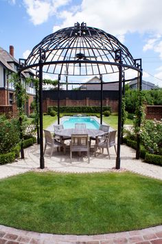 an outdoor dining area with a pool and gazebo in the back yard on a sunny day