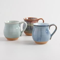 three ceramic mugs sitting next to each other