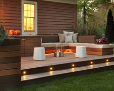 an outdoor living area with lights on the deck