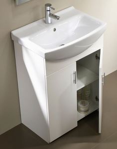 a white bathroom sink sitting next to a wall mounted faucet under a mirror