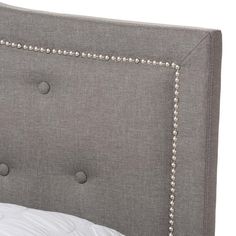 an upholstered headboard with studding and buttons on the back of it