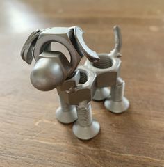 two metal dog sculptures sitting on top of a wooden table