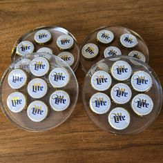 two clear plates with white and blue life badges on them sitting on a wooden table