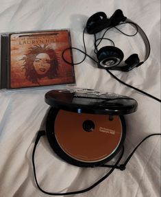 a cd and headphones laying on top of a bed