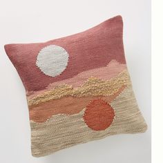 a decorative pillow with an orange, pink and white design on the front is shown