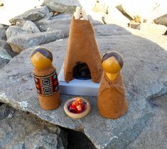 two stuffed animals sitting on top of a rock next to a bowl and bottle opener