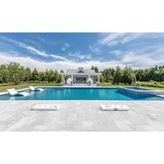 a large swimming pool with lounge chairs around it