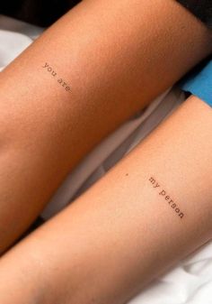 two people with matching tattoos on their arms, one has the word love written on it