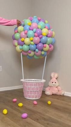 a girl in pink jumping up into a basket filled with balloons