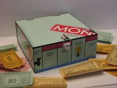 an unopened monopoly box surrounded by money