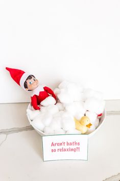 an elf is sitting in a bowl of marshmallows