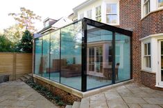 a glass enclosed patio in front of a house