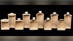 a group of ceramic containers sitting on top of a black table next to each other