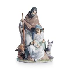 a figurine of jesus holding a baby in his lap and two animals around him