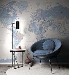 a blue chair sitting in front of a wall with a world map on the wall