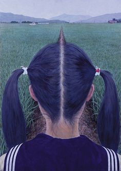 the back of a woman's head with long black hair in front of a green field