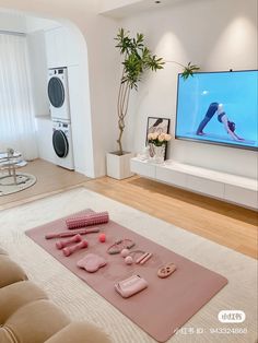 a flat screen tv sitting on top of a white wall in a living room next to a couch