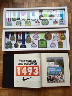 an open book with medals hanging from it's front and back sides on a wooden floor